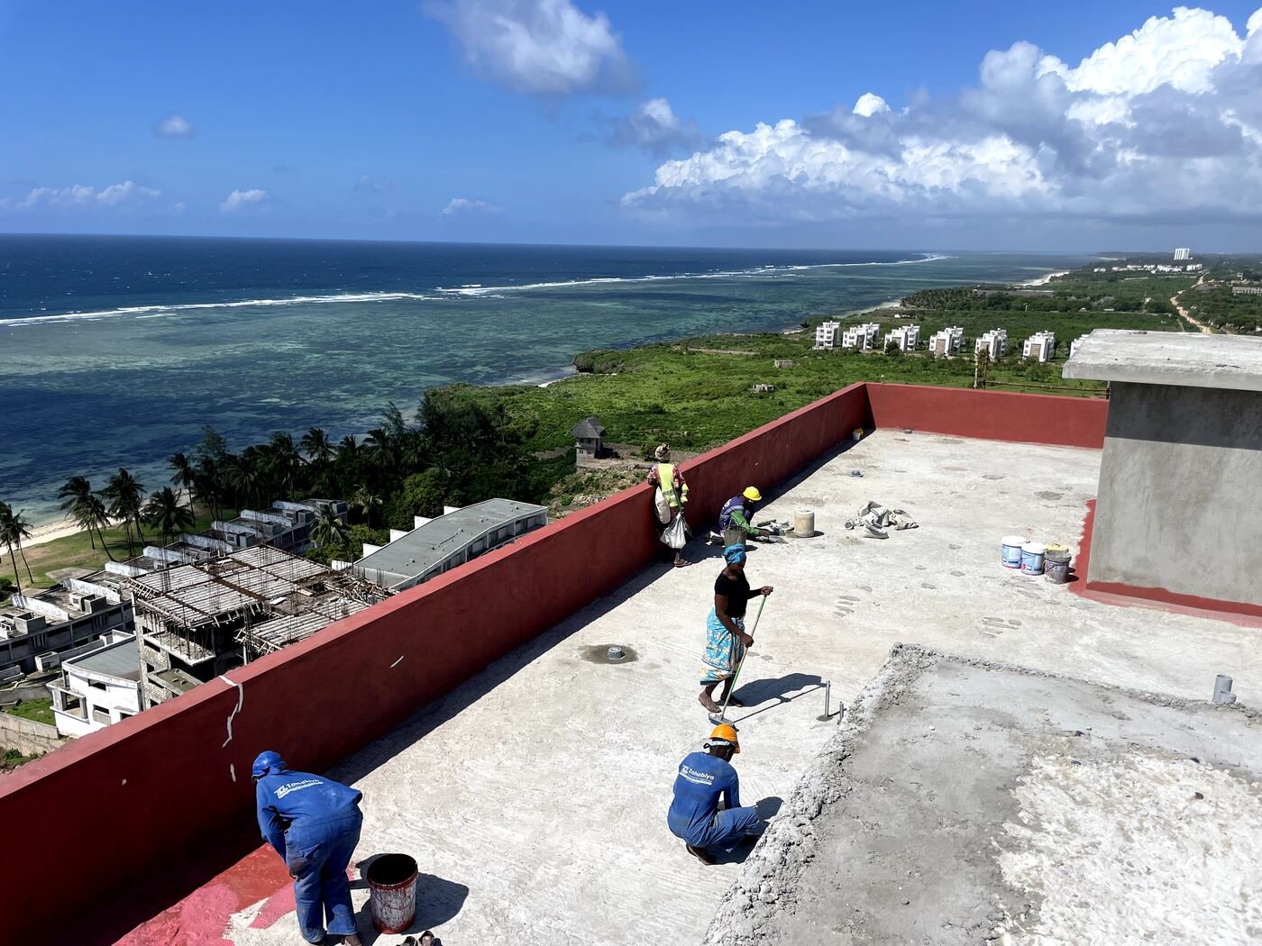 Kifaru team applying waterproof membrane on a coastal rooftop in Kenya